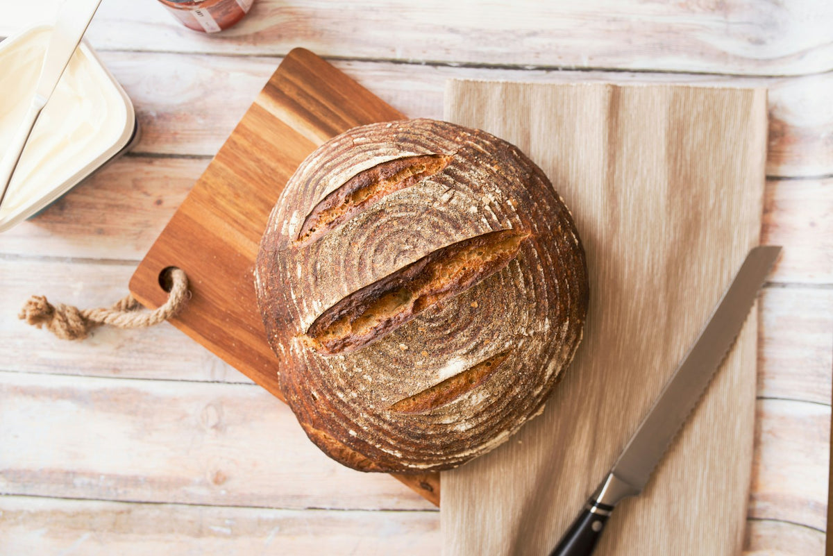 A loaf of bread on a wooden chopping board