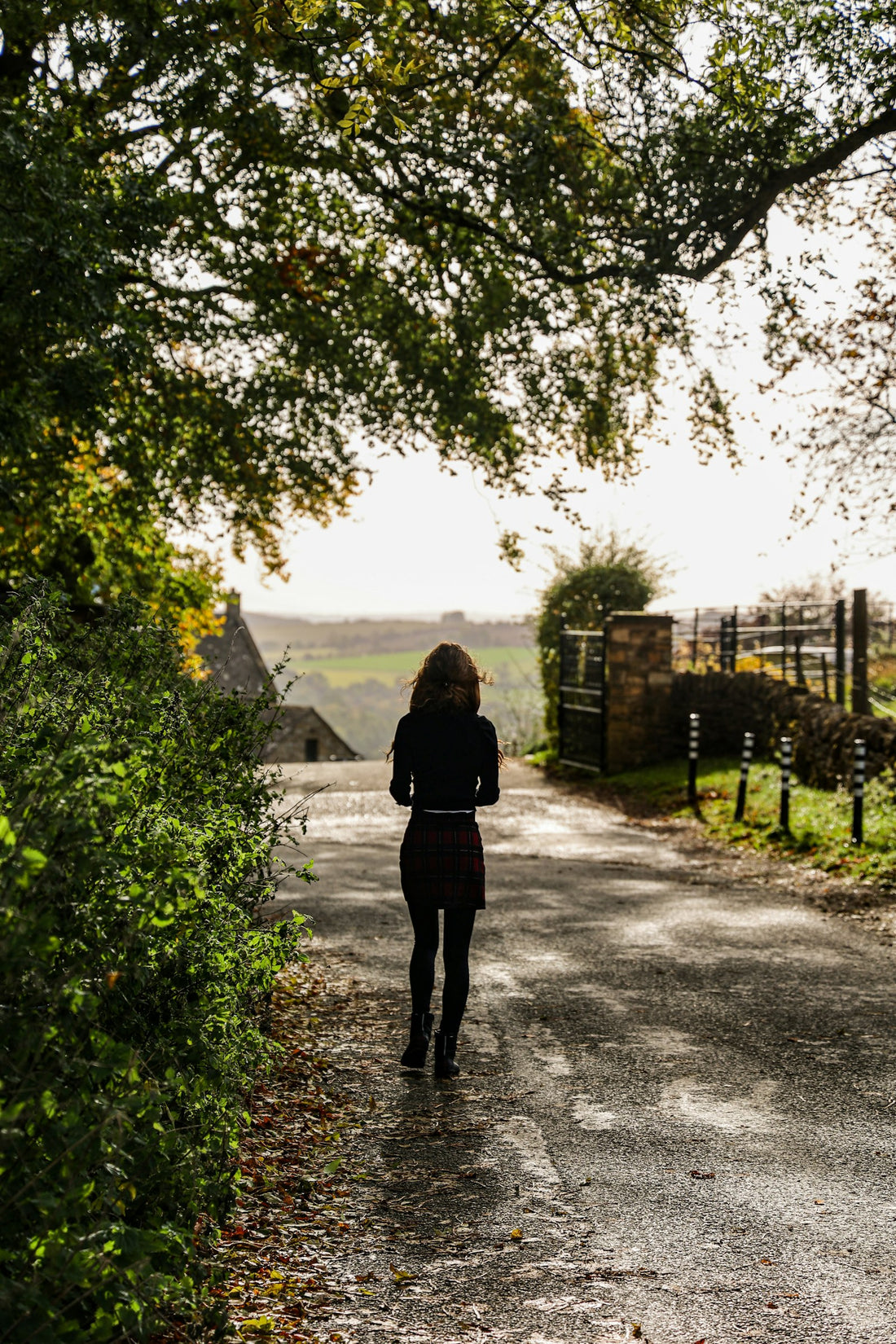 A walker on a country track beside a green field