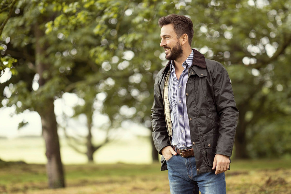 Man walking in English woodland wearing a waxed jacket