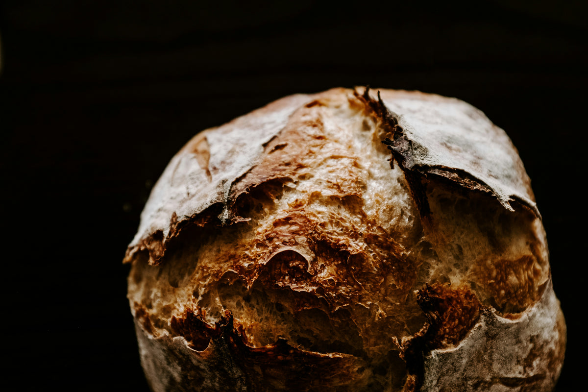A crusty loaf of bread on a wooden surface