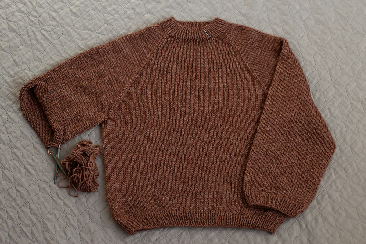 A rust-coloured knitted wool jumper