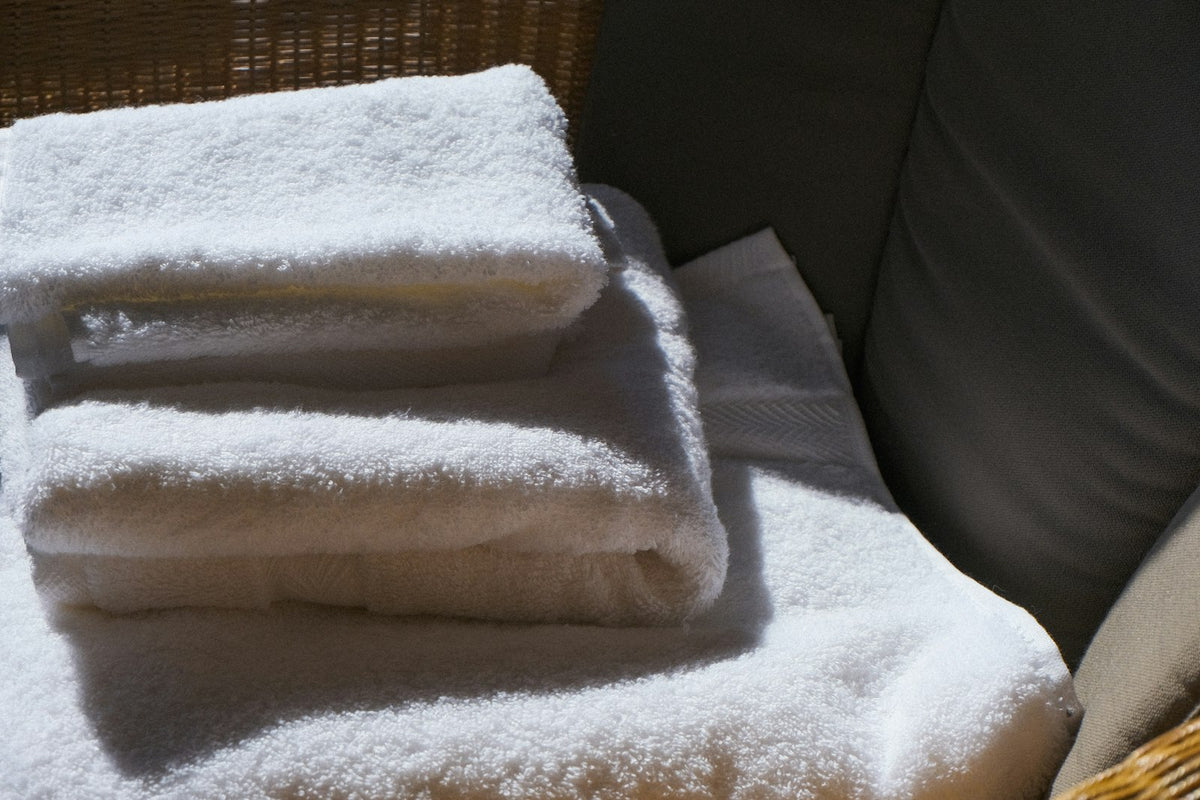Stack of soft white towels in warm morning light
