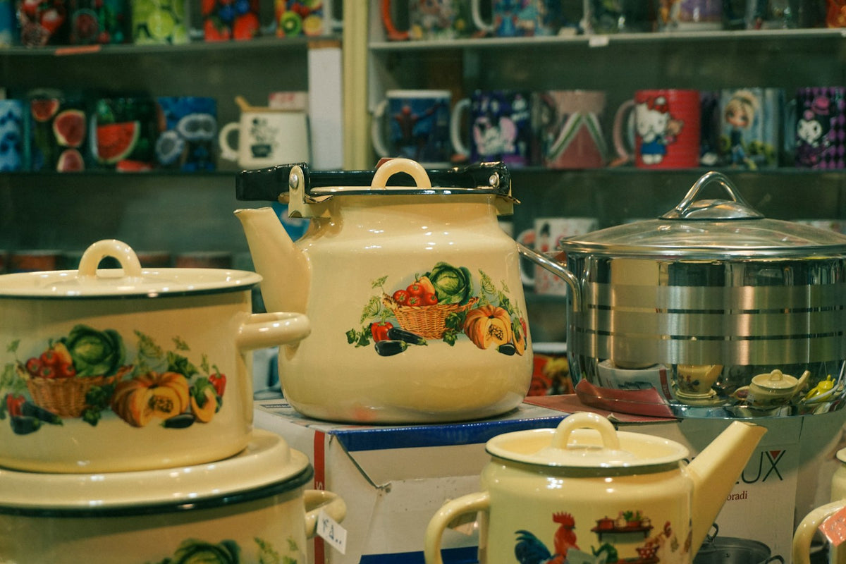 Cream enamel teapots and pots displayed together