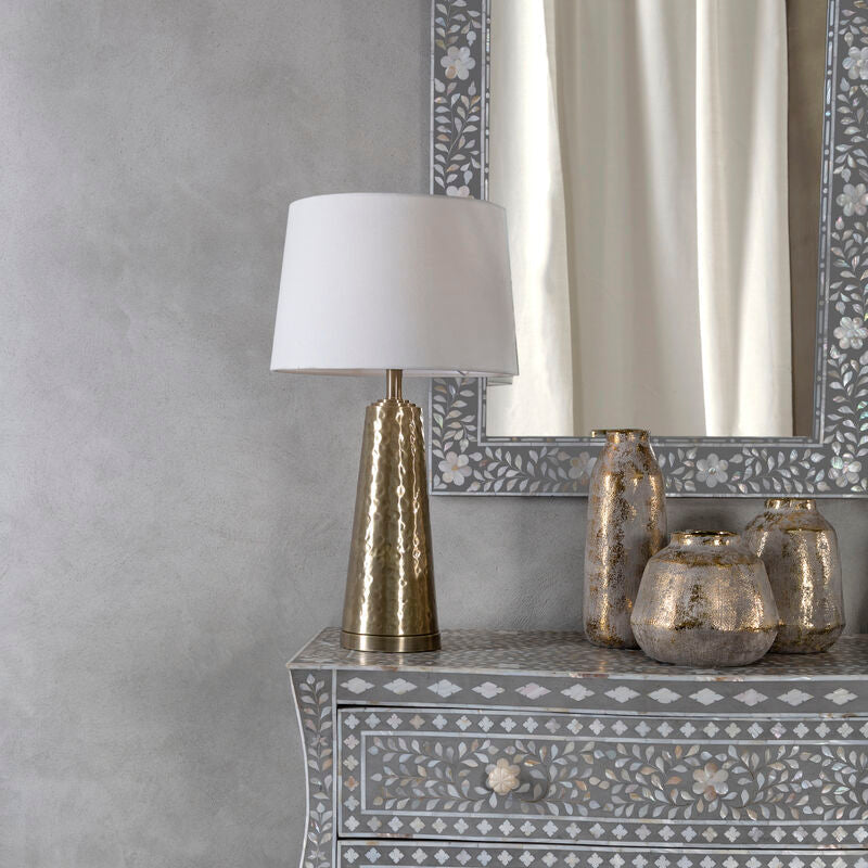 Antique brass table lamp with cream shade in a sitting room