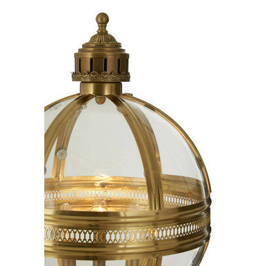 Brass globe table lamp lit, showing candle-style lights inside the glass