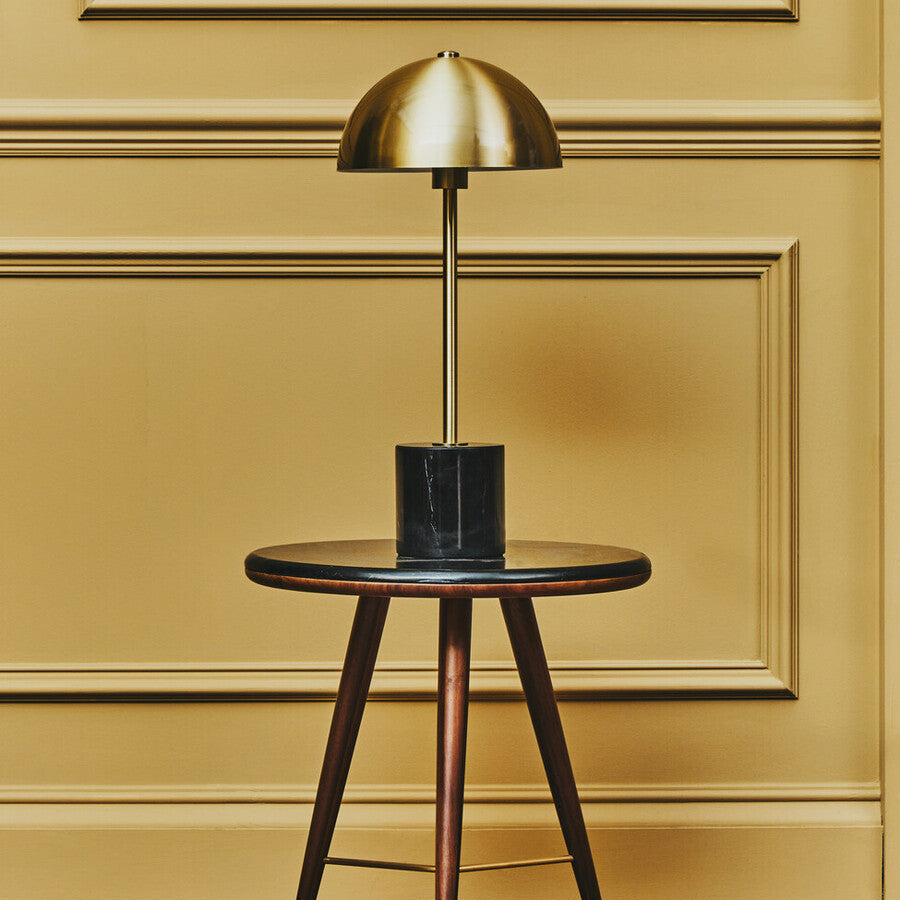Brushed brass dome table lamp on a black marble base