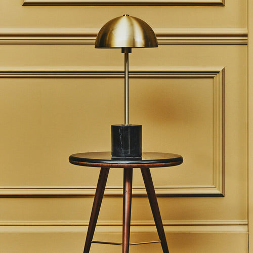 Brushed brass dome table lamp on a black marble base