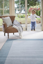 Duck egg blue bordered wool rug in a room