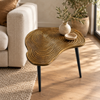 Brass clover side table beside a chair